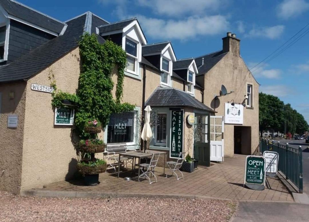 The Denholm Meet's stone frontage with outdoor tables on Westside